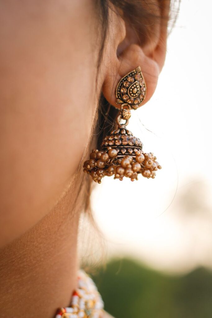 elegant gold jhumka earring on woman s ear